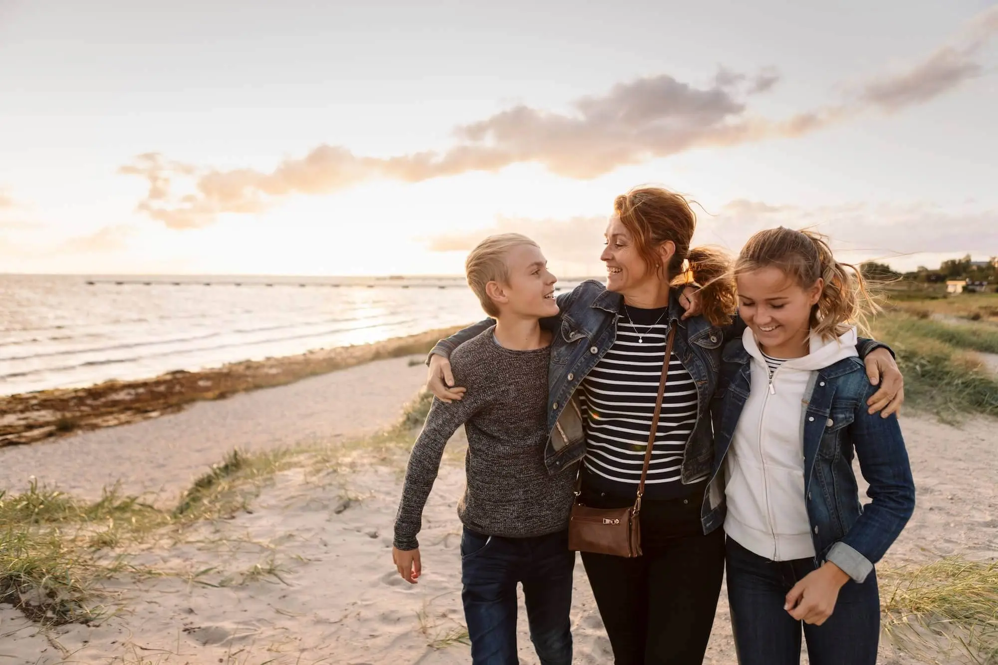 Smiling mother and children at beach during weekend