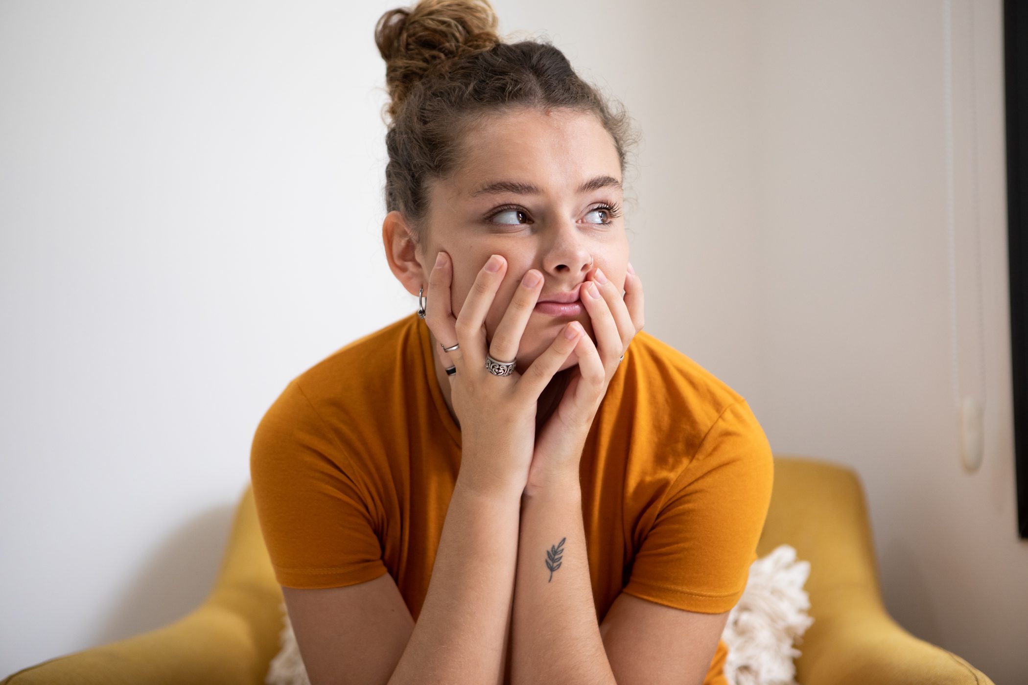 Woman looking upset with her hands in her face.